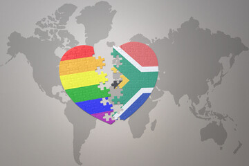 puzzle heart with the rainbow gay flag and south africa on a world map background. Concept.