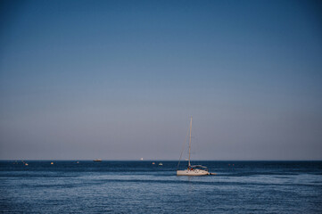 white sailing yacht stands in a bay on sea on sunny summer day with a blue sky