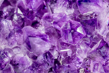 Amethyst purple crystals. Gems. Mineral crystals in the natural environment. Texture of precious and semiprecious stones. Seamless background with copy space colored shiny surface of precious stones.