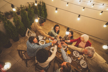 Family and friends celebrating at dinner on a rooftop terrace