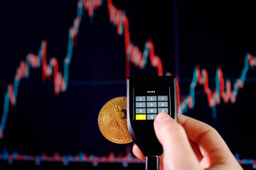 Close up womans hand holding bitcoin and enter the password on cryptocurrencey hardware cold wallet...