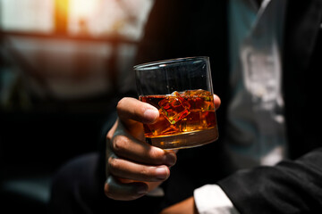 Closeup businessmen holding a glass of whiskey