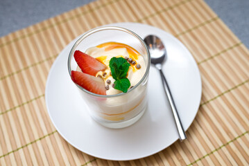 Strawberry parfait with mango sauce decorated with mint leaves