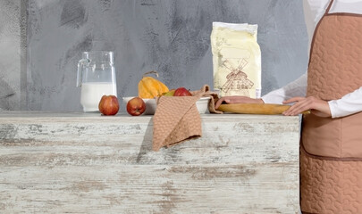 Woman in a brown apron in the kitchen in the process of cooking