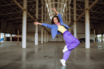 Young  woman - dancer dancing  in the underpass. Sport, dancing and urban culture concept.