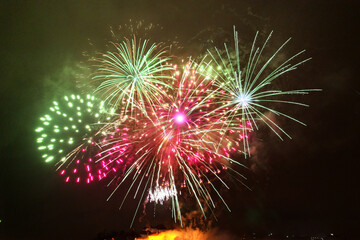 Green and red fireworks light up the night sky during the New Year's Eve celebration