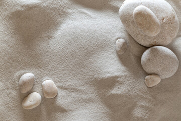 Fototapeta na wymiar light fine sand with round stones, peace meditation, background