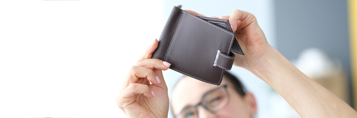 Woman looking into an empty wallet, close-up