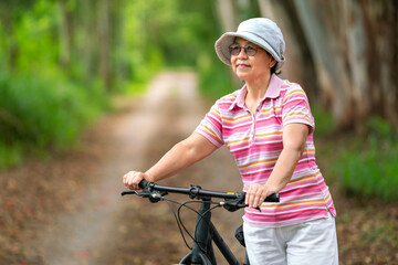 Naklejka premium senior business woman, female, ride or bike mountain bicycle in country park near home town for healthy exercise in summer weekend