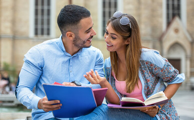 Campus life. Young couple learning together in the park. Education, love and tenderness, dating, romance, lifestyle concept