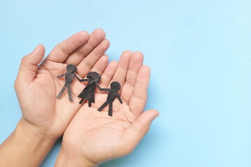 Hand holding children paper cutout. Child abuse rehabilitation, custody, human rights and refugee...