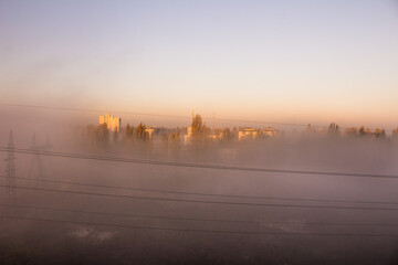 Fog and smog in the city. Power line. Pole wires. Power line top view from the window. Morning in...