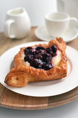 Sweet cherry and cream, puff pastry dessert on white plate , diamond shaped.