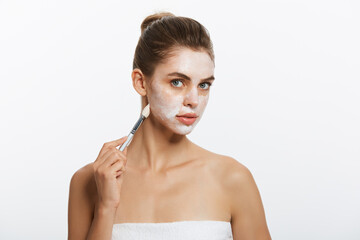 Portrait beautiful naked woman apply cosmetic white clay mask on with brush. Isolated on a white...