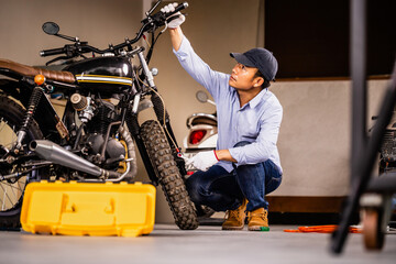 Repairing and maintenance concepts, Man repairing motorcycle in repair shop, Mechanic fixing and...