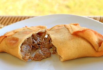 Empanada de Pino or beef filled Empanada, delicious Chilean baked pasty served on white plate