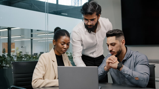 Arab Man Coach Leader Boss Talking About Mistake Explain Indian Teacher Mentor Teaching Interns Managers Employees Use Online App Help With Software Diverse Team Looking Laptop Discussing Project