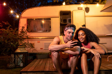 young couple on vacation with the camper - obrazy, fototapety, plakaty