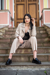 Obraz premium Portrait of young girl in stylish white clothes posed against door at old house.