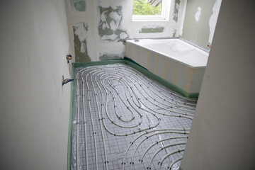 Shot of construction site in a loft where underfloor heating has just been installed, white pipes...