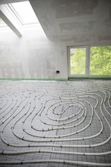 Obraz premium Shot of construction site in a loft where underfloor heating has just been installed, white pipes on grey mat