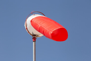 red windsock against clear blue sk