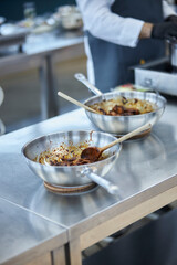 Asian style chicken cooking process. Chicken pieces in unagi sauce in a wok 