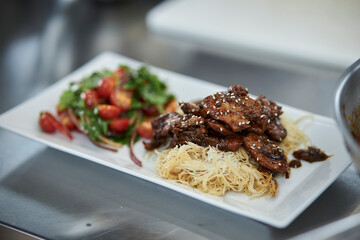 Asian noodles with beef and salad with fresh vegetables. 