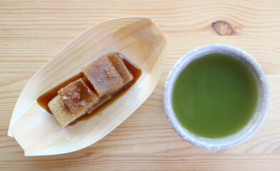 Delectable Japanese Traditional Confection Called Warabimochi in Kuromitsu Syrup with a Cup of Hot Matcha Green Tea