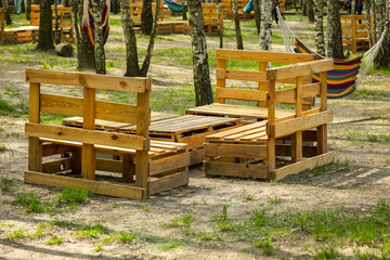Wooden palette made garden seats on the green lawn. . Photo taken on a sunny day. Objects in a...