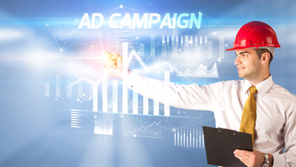 Young businessman with helmet drawing on virutal screen