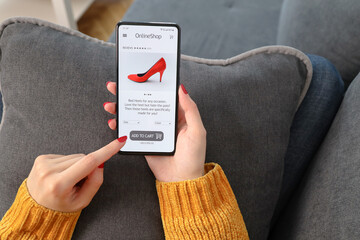 Woman buy red shoes online with e-commerce app or web site with smart phone. Girl holding smart...