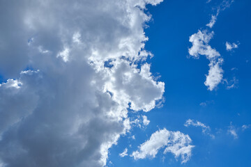 Background cumulus clouds against a blue sky illuminated by sunlight.