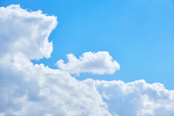 Background cumulus clouds against a blue sky illuminated by sunlight.