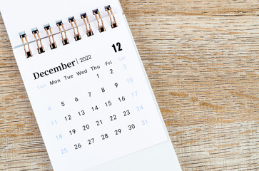 December 2022 desk calendar on wooden background.