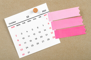 October 2022 calendar with blank adhesive note paper on brown background.