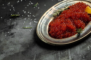 Delicious red caviar in vintage plate on dark background. banner, menu, recipe. selective focus, place for text