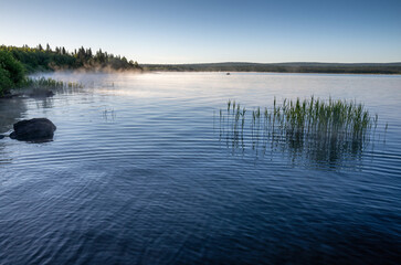 Southern Urals, Zyuratkul National Park. Fishermen are fishing from a boat in the early morning.