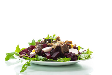 Salad with boiled beets, fried eggplants, herbs and arugula in a plate