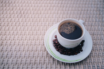 Fresh tasty espresso cup of hot coffee with coffee beans with orange flar