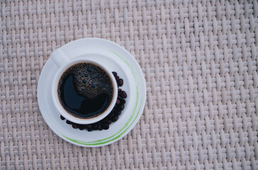 Fresh tasty espresso cup of hot coffee with coffee beans