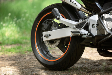 motorcycle wheel on the ground in the forest at sunset