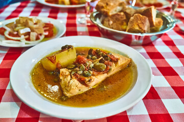 Stockfish (white/ without tomatoes) in Messina style. Cod stewed with cherry tomatoes, caper, olive oil and potato. Traditional plate of Messina, Sicily, Italy