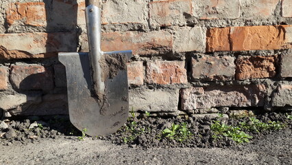 agriculture tools. dirty shovel on brick wall background 