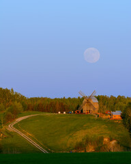 Wschód księżyca nad wzgórzem z wiatrakiem na Kaszubach w Polsce - obrazy, fototapety, plakaty