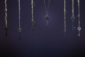 many vintage keys hang on a rope on a dark background