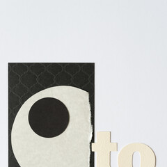 part of the word "to" and paper shapes (one a circle) on a light background