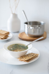 Table setting at home. Eating soup at dinner. Fresh vegetable soup with chicken broth. Healthy food concept. Minimalism in the kitchen in the interior.