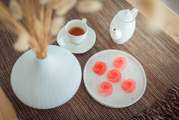 Pink jelly desserts with a set of tea on the table. (selective focus)