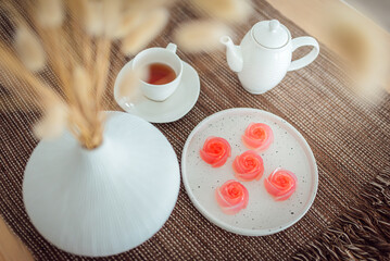 Pink jelly desserts with a set of tea on the table. (selective focus)